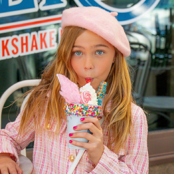 Girl sipping a straw from a Sweet Tooth killer milkshake