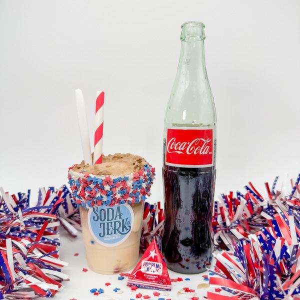 Firecracker Float Firecracker Float in a Soda Jerk cup next to a Cocoa-Cola bottle with patriotic decorations.
